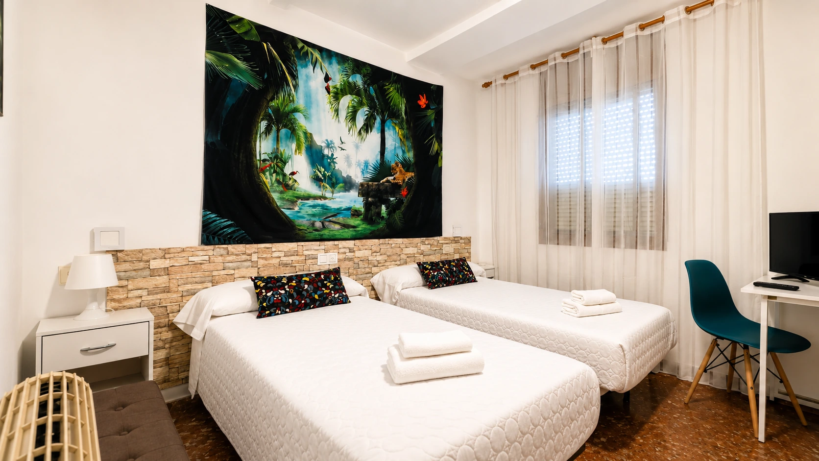 Room with two single beds, wide window and jungle mural