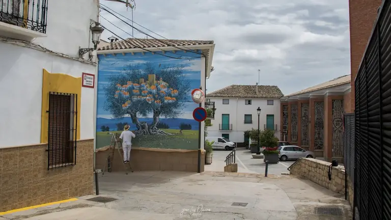 Faustillo pintando un mural del olivar en Peal de Becerro